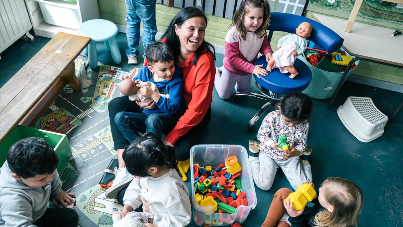 Liesbeth Van Beersel, zorgcoördinator, speelt met samen met haar klas met poppen en blokken