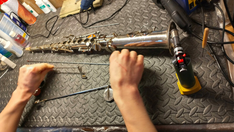 2 handen repareren saxofoon
