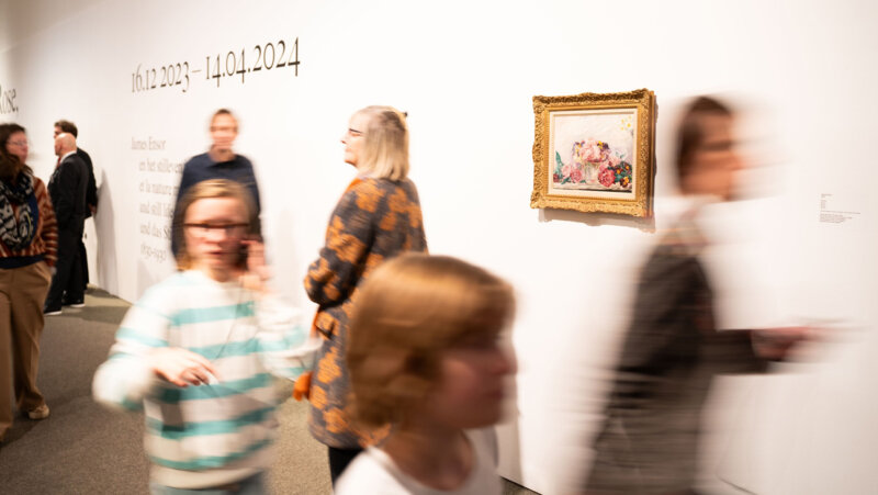 Bezoekers wandelen voorbij aan schilderij van James Ensor