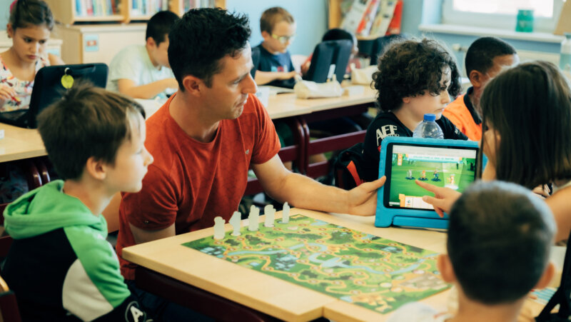 Stijn bekijkt op de iPad het spel met de leerlingen