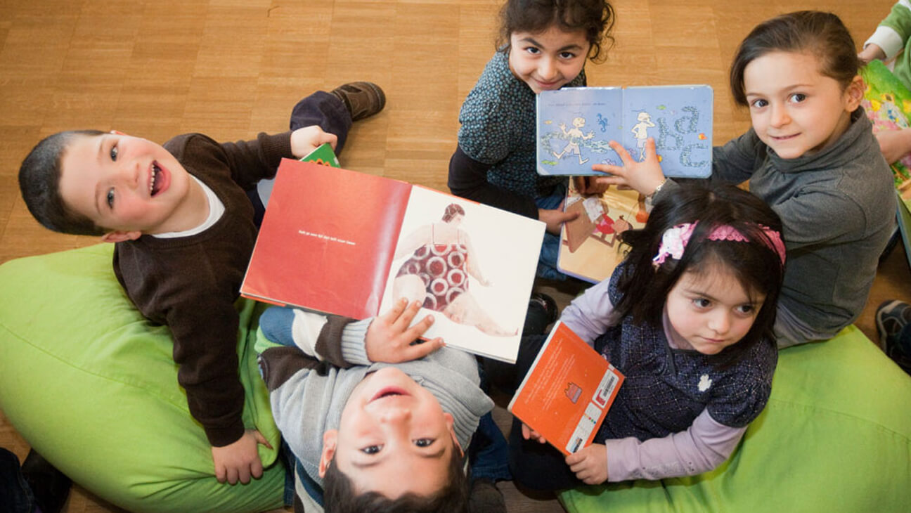 Kinderen lezen boeken in de Bibliotheek Genk