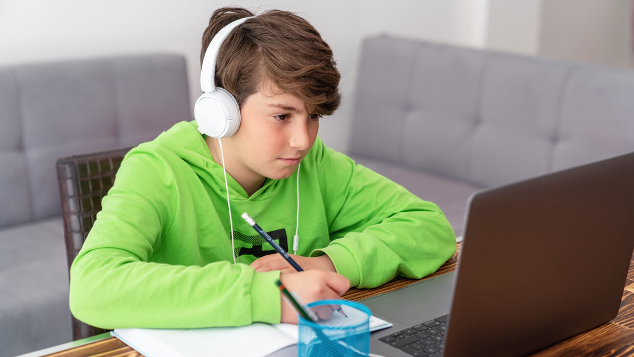 Jongen maakt huiswerk met voorleessoftware
