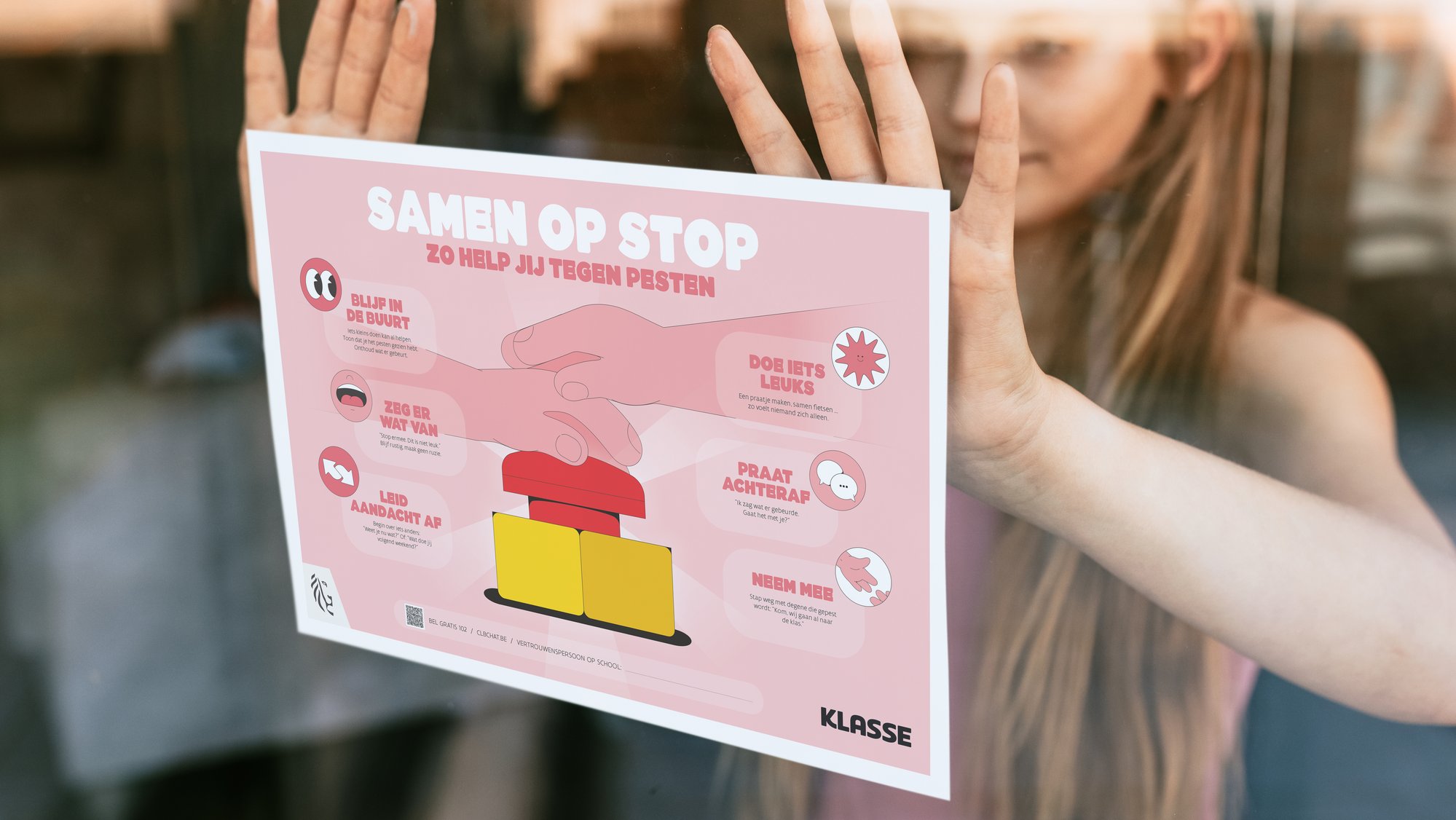 Leerling hangt poster tegen pesten op met tips voor omstaander