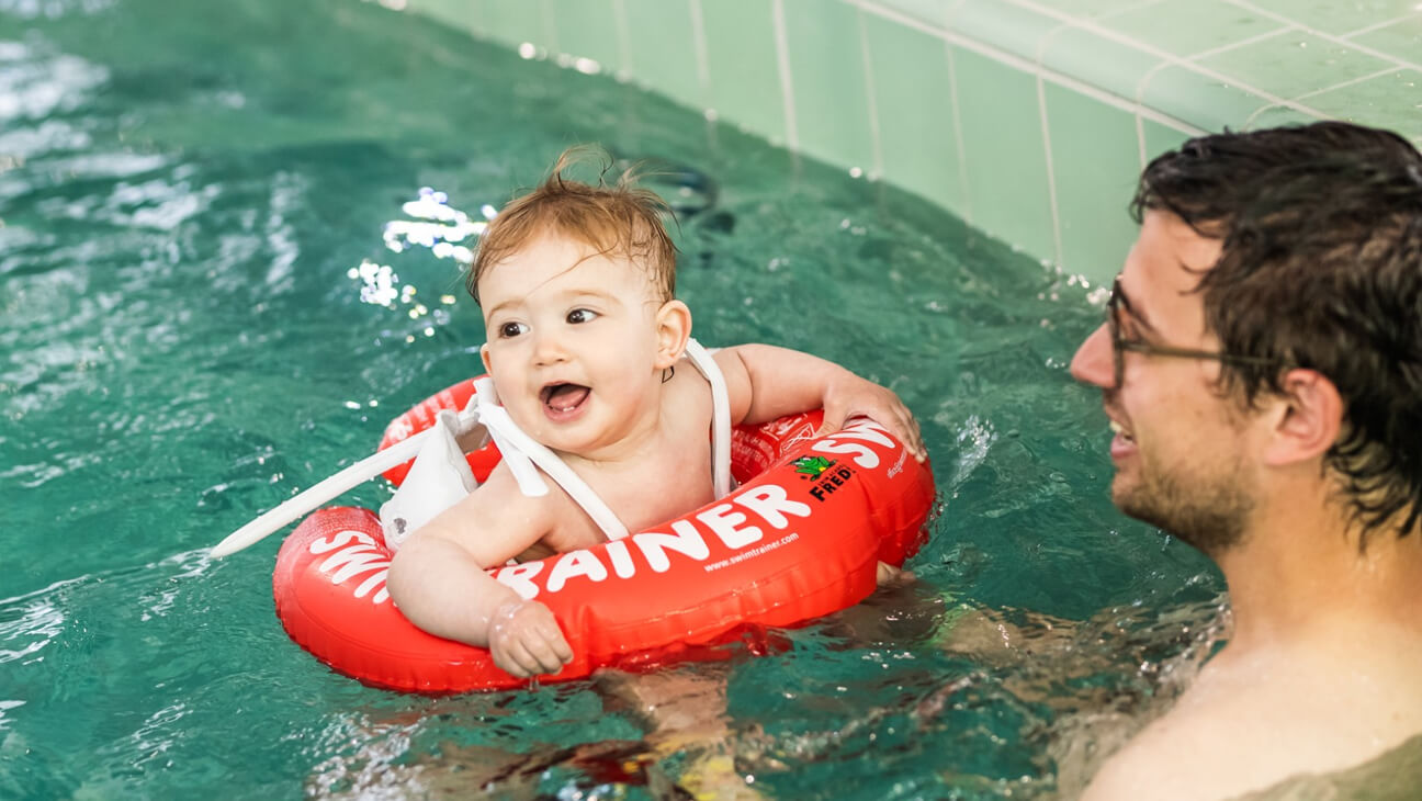 Kind met papa in zwembad van Lago