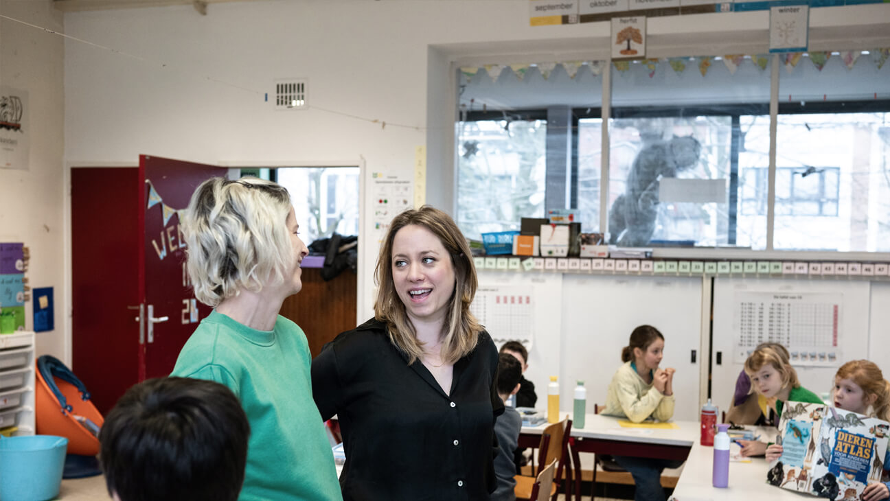 Directeur Kelly Thyssen praat met leraar in de klas