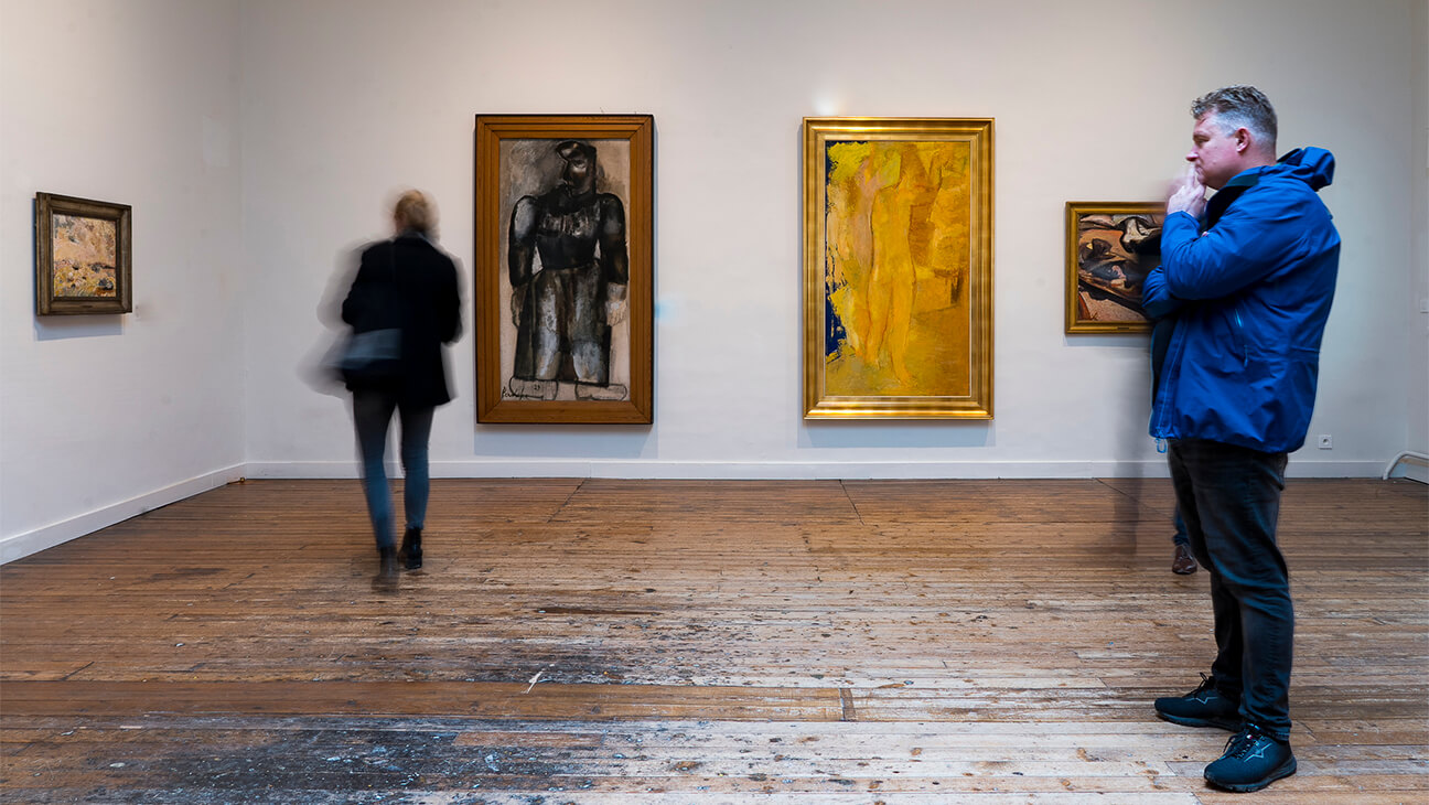 Bezoekers in het Permekemuseum kijken naar schilderijen