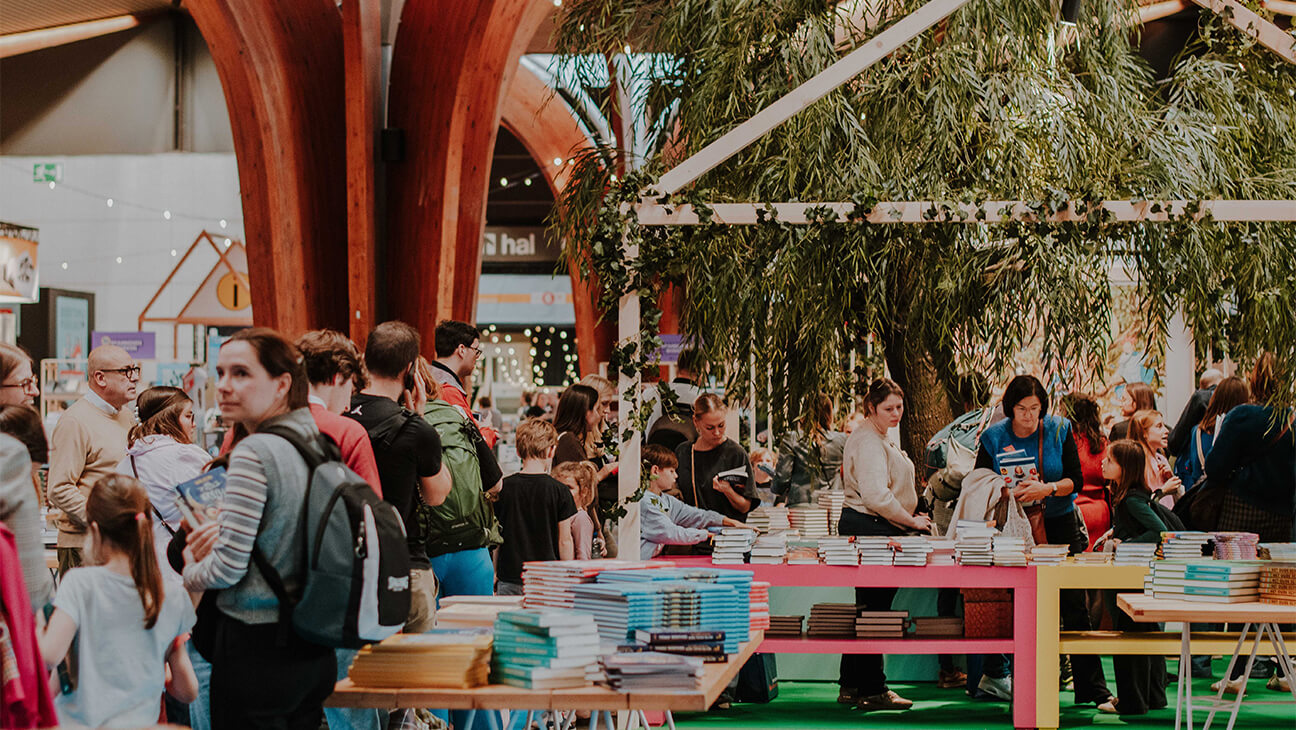 Bezoekers tussen rekken met boeken op Boektopia