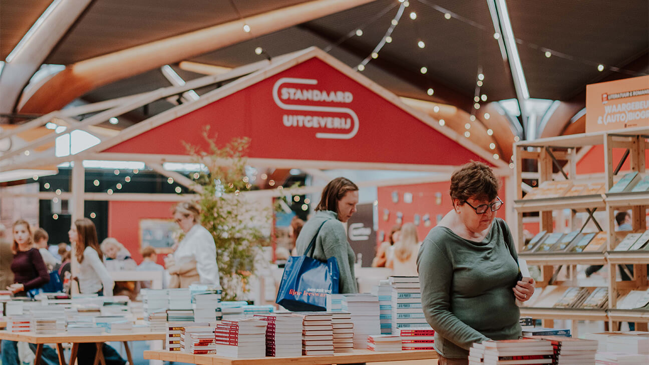 Bezoekers tussen rekken met boeken op Boektopia