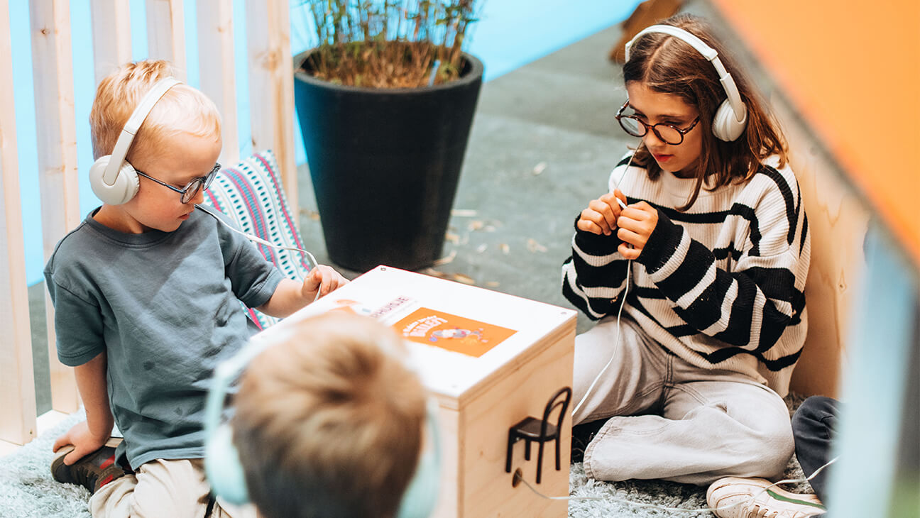 Kinderen luisteren naar een boek met een hoofdtelefoon op Boektopia