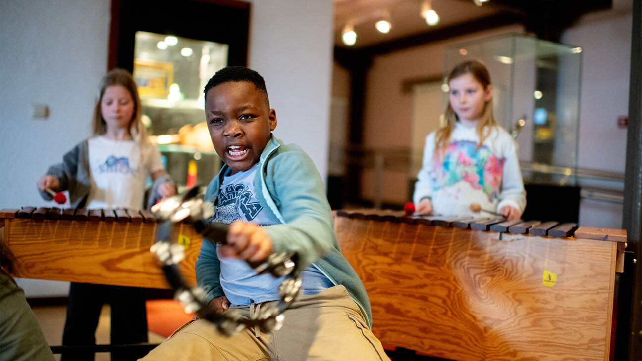 Jongen met een cimbaal en 2 meisjes op een xylofoon