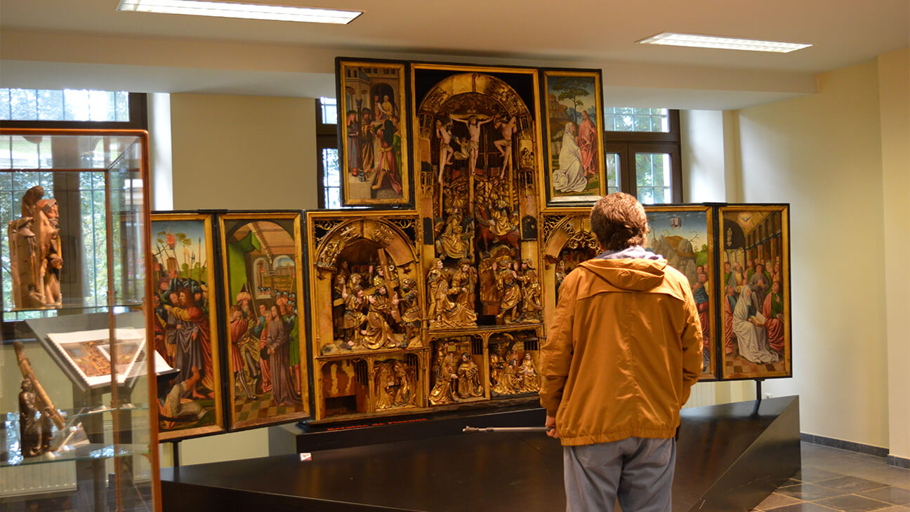 Man kijkt naar een groot schilderij in Musée Gaspar