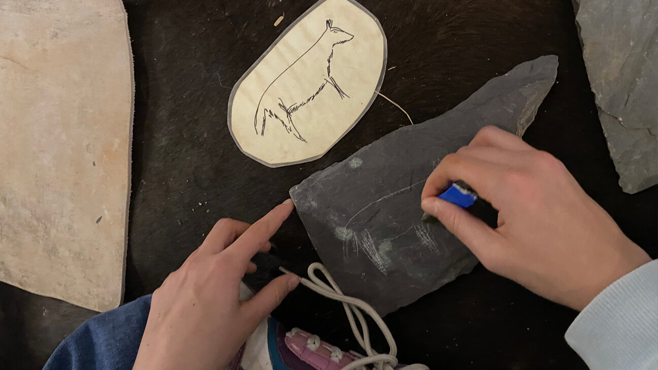 Iemand schrijft op een oude leisteen