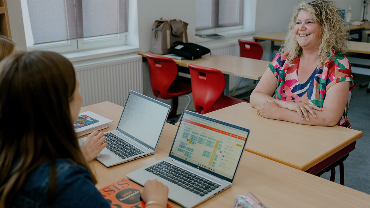 leraar bij een laptop in de klas