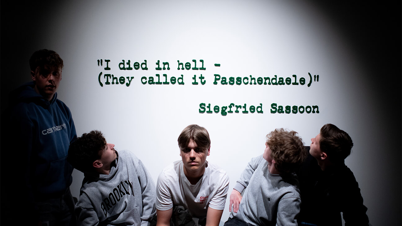 Leerlingen voor een spreuk op een muur in Passchendaele Museum