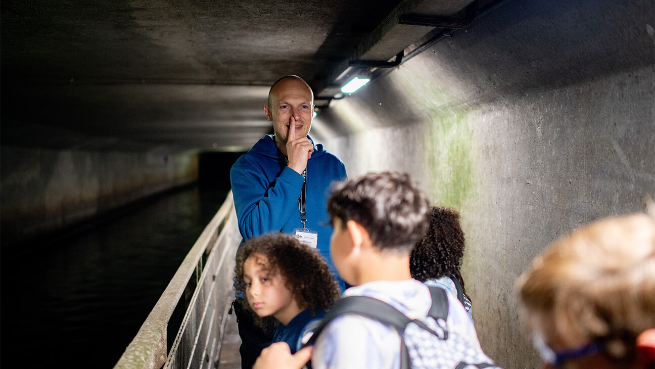 Klas met gids in het riolenmuseum