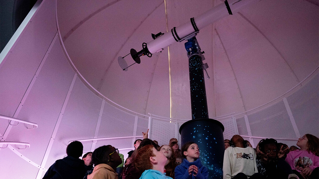 Klas bij een telescoop in Cosmodrome in Genk