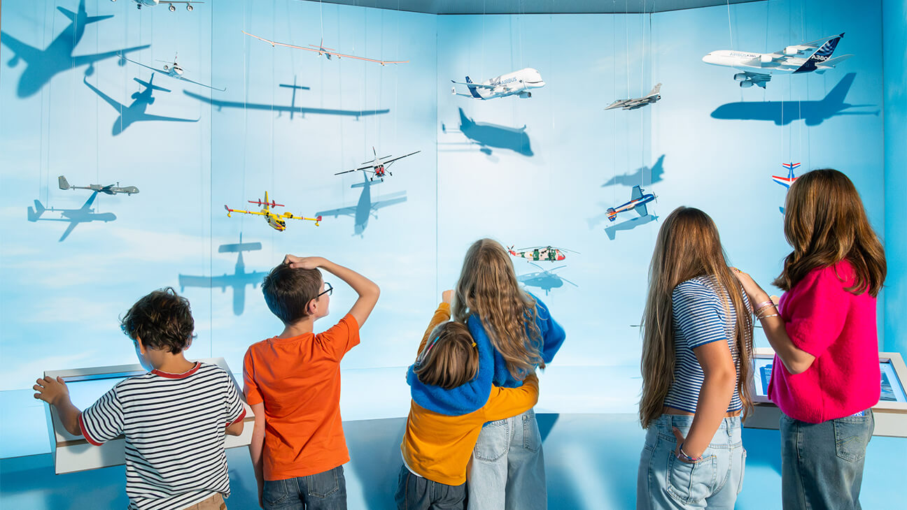 Bezoekers aan de expo 'Flight' kijken naar verschillende vliegtuigen