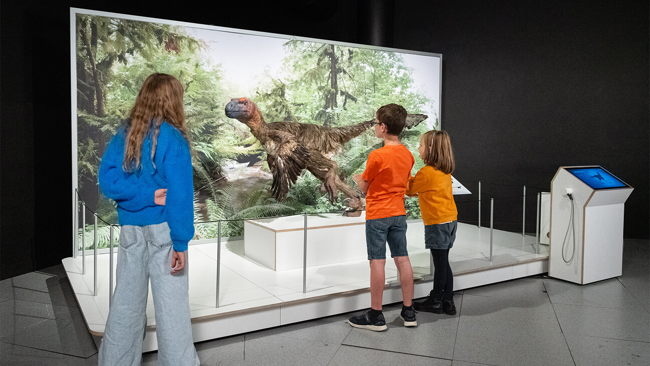 Bezoekers aan de expo 'Flight' kijken naar een dino