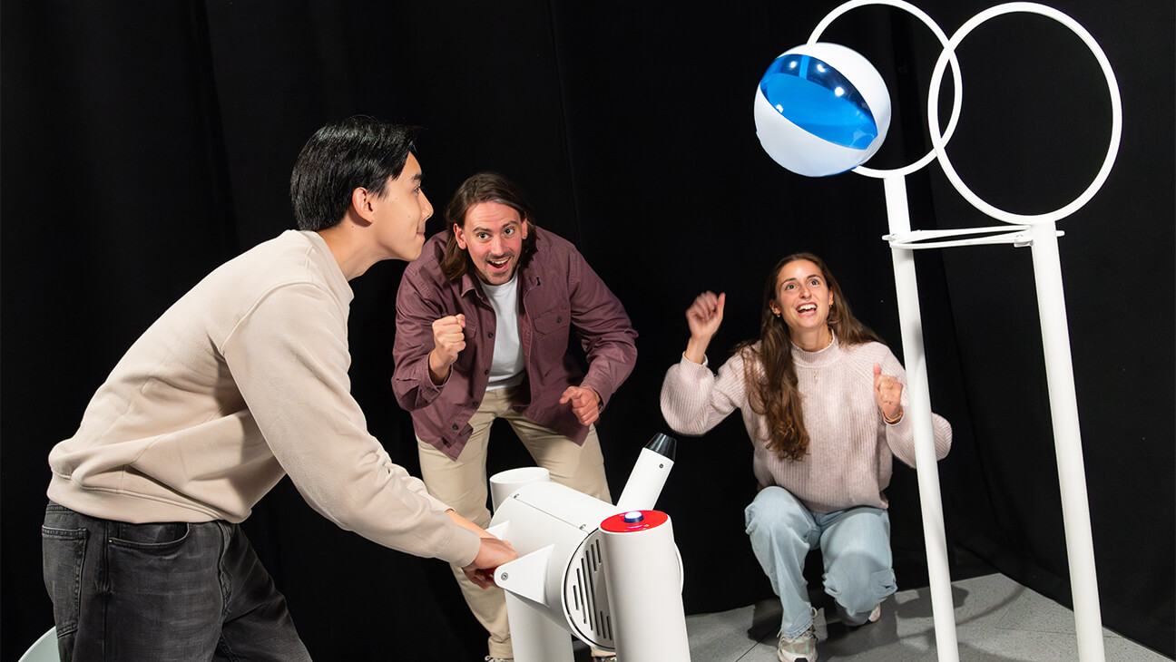 Bezoekers aan de expo 'Flight' houden een strandbal omhoog