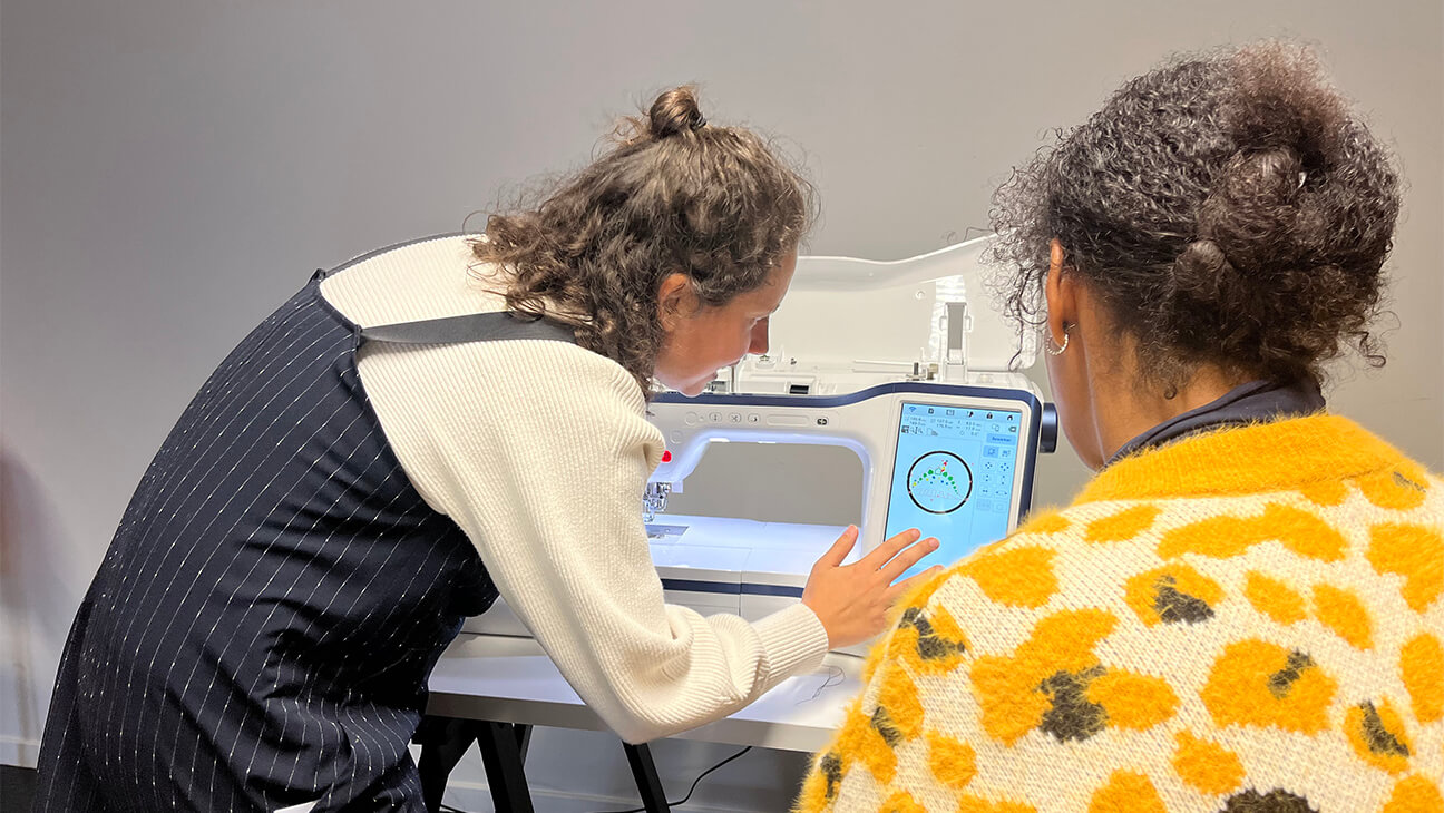 Vrouw stelt een borduurmachine in bij Fabzero