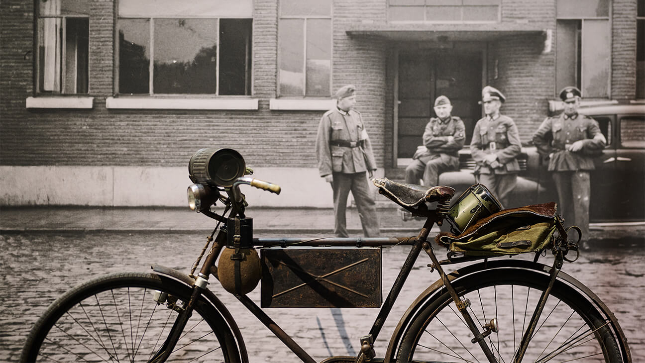 Oude foto van soldaten bij een fiets