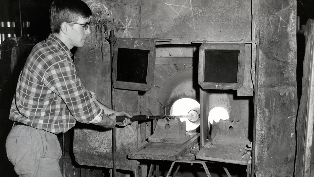 Man met glaswerk in een oven