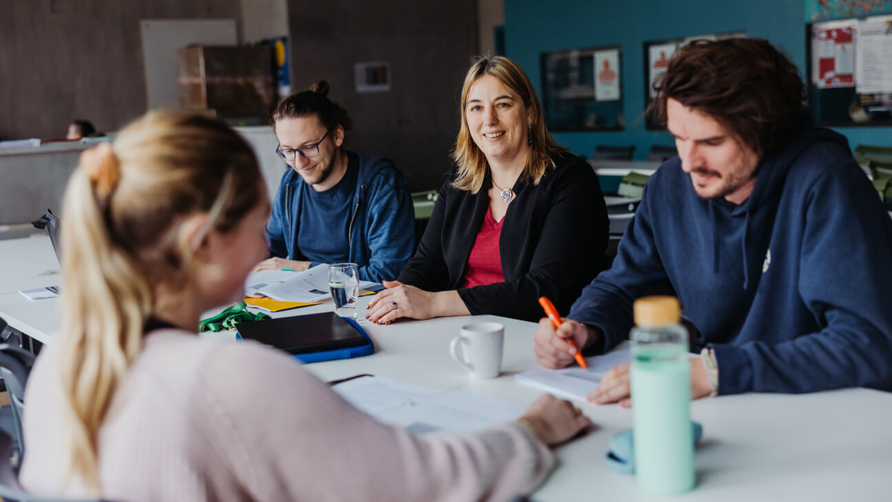 Lerarenkamer met leraren die meeschuiven met hun leerlingen