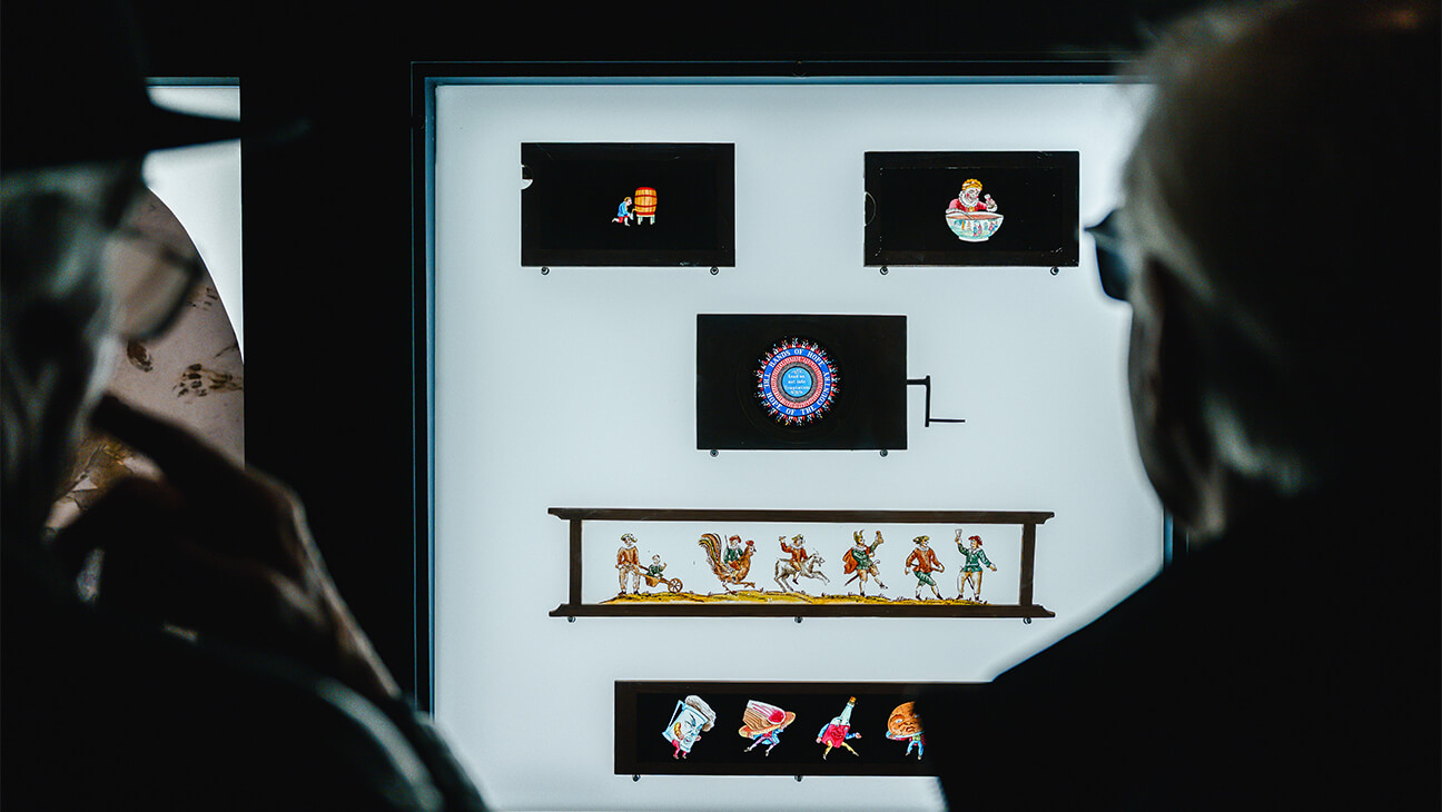 Mensen kijken naar kunstwerken op de Expo De schaduw van de fles. Een beeldstrijd van glasplaat tot film