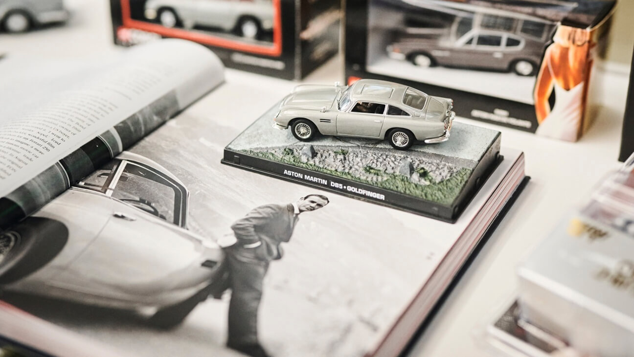 Oude speelgoedauto van Aston Martin op de expo 'Aston Martin - Elegance in motion'