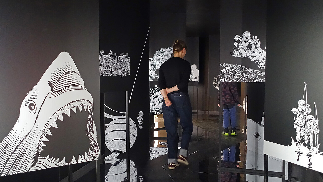 Bezoeker in zaal in de expo Alleen in het Stripmuseum