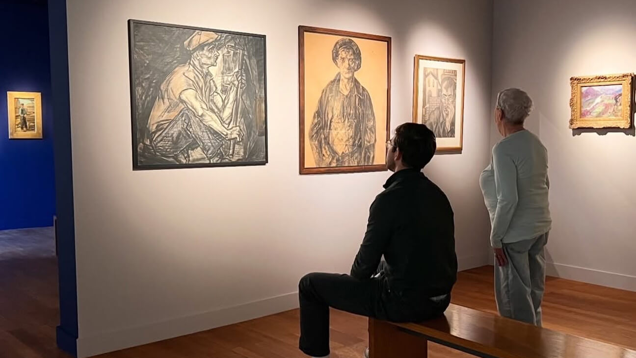 Bezoekers kijken naar schilderijen op de expo Licht over de fabriek