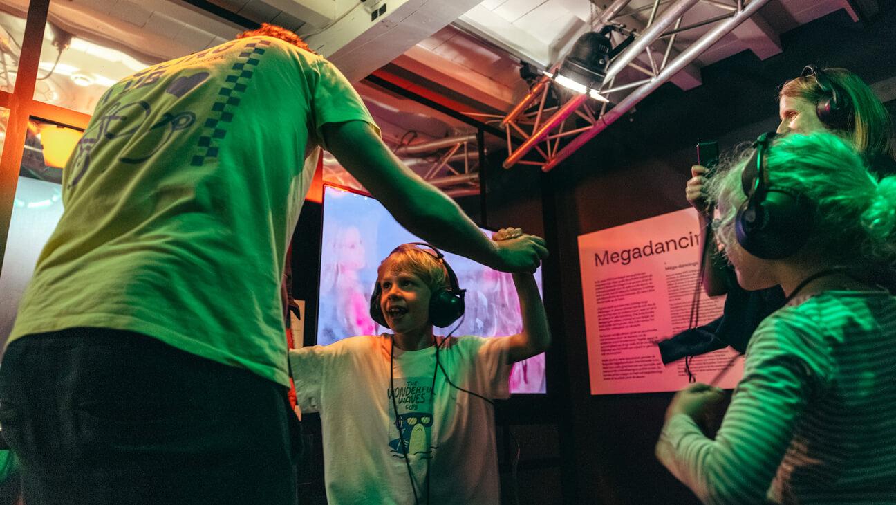 Mensen dansen op muziek tijdens expo 'C'est Party! in Huis van Alijn