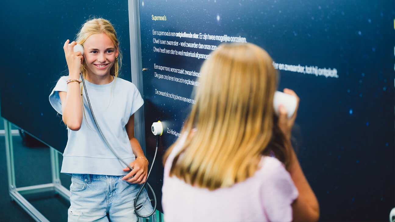 Kinderen op de expo 'einsteintelescoop' luisteren naar een audiofragment