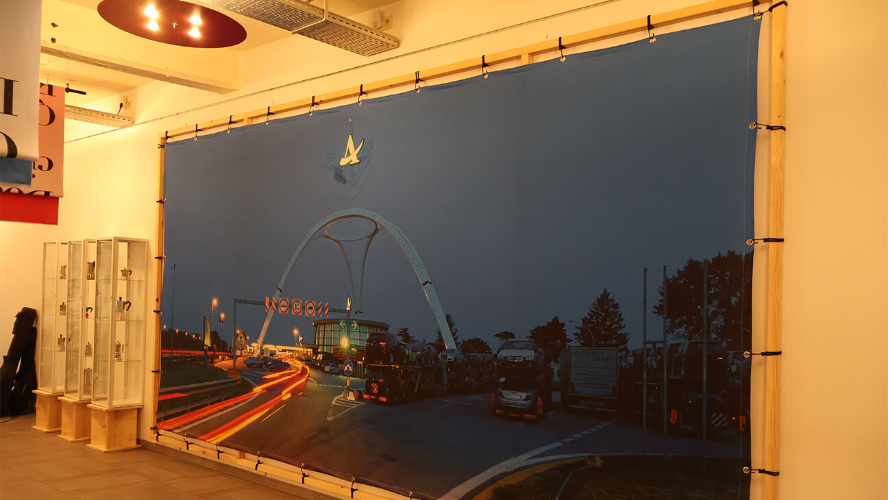 Zaal met een grote poster met daarop gedrukt een drukke snelweg en brug