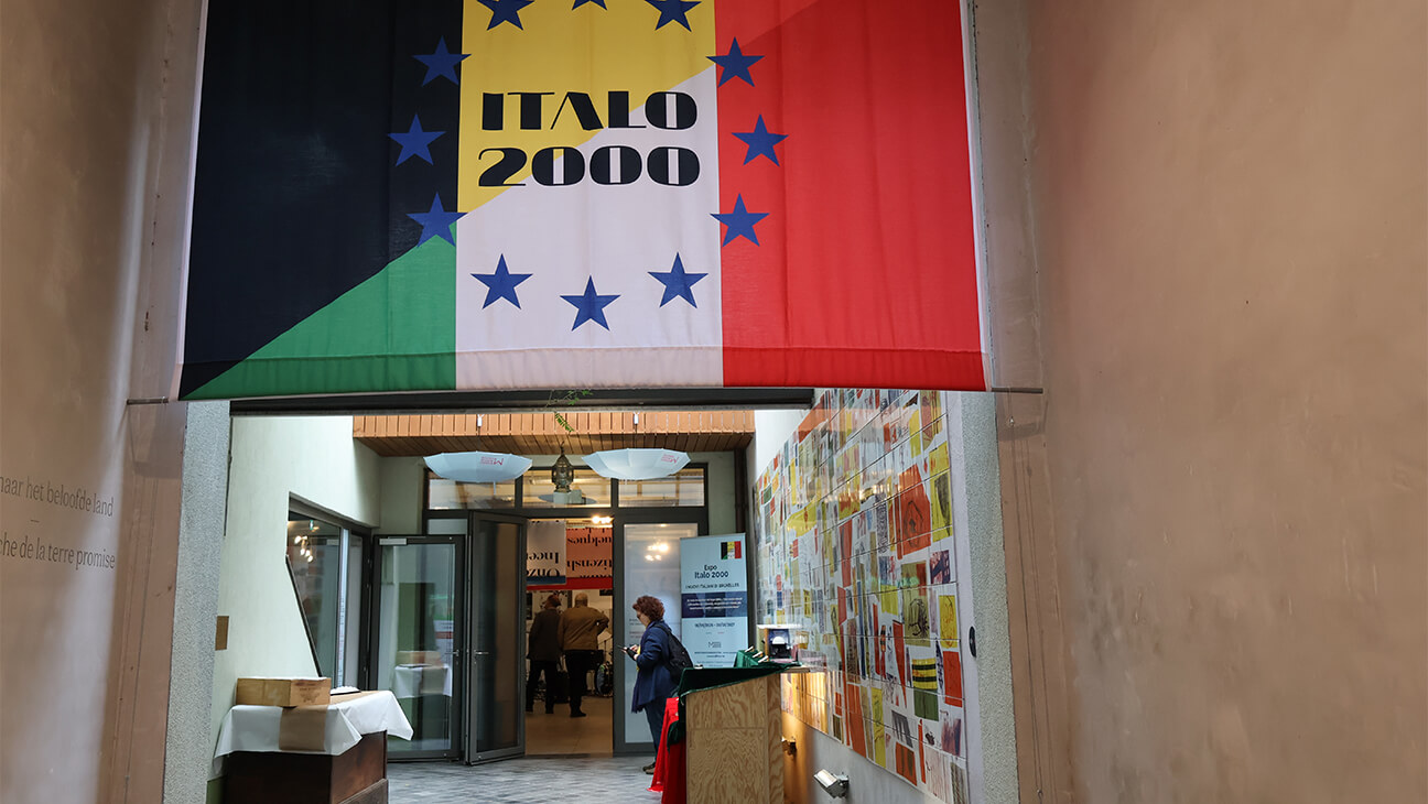 Grote italiaanse vlag met het opschrift 'Italo 2000' hangt boven een gang