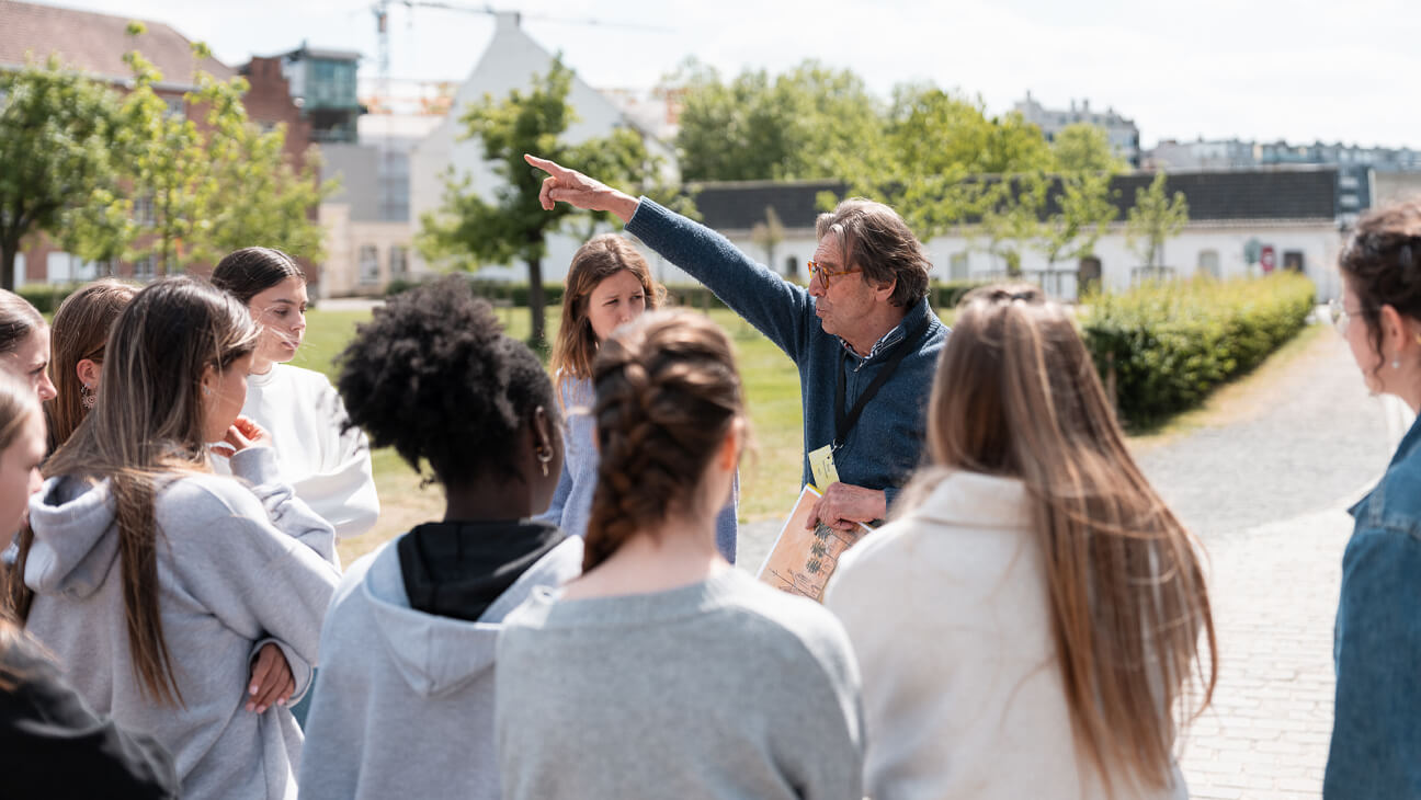 Gids wijst iets aan een groep leerlingen