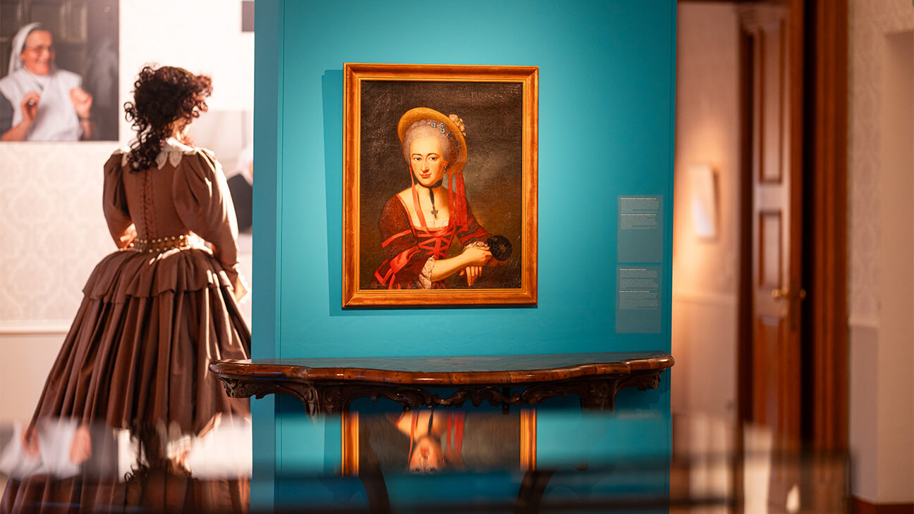 Oud schilderij van een vrouw op een blauwe muur