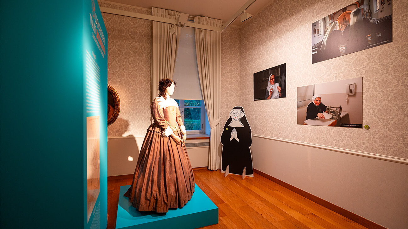 Zaal met foto's van nonnen en een mannequin met bruin kleed