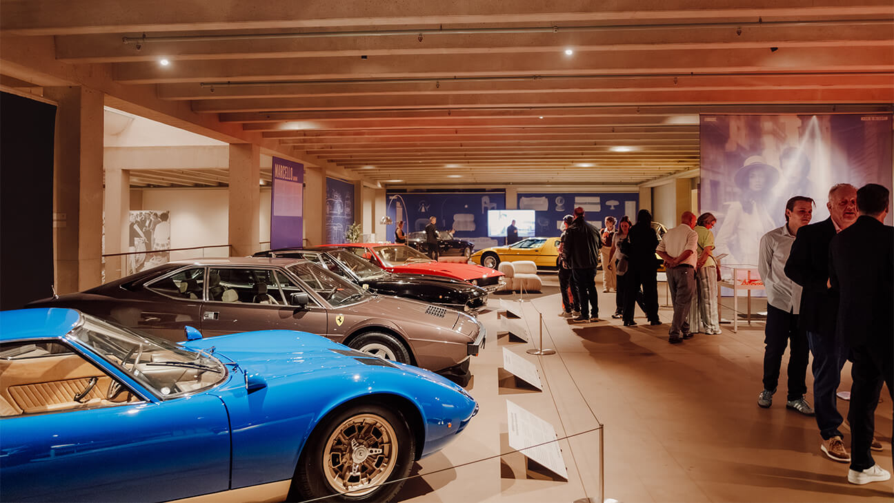 Zaal in een museum met een rij sportwagens