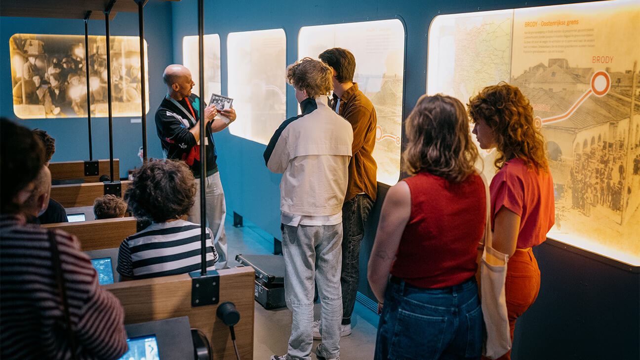 Bezoekers kijken naar grote foto's in een zaal tijdens de expo 'tussen talen'