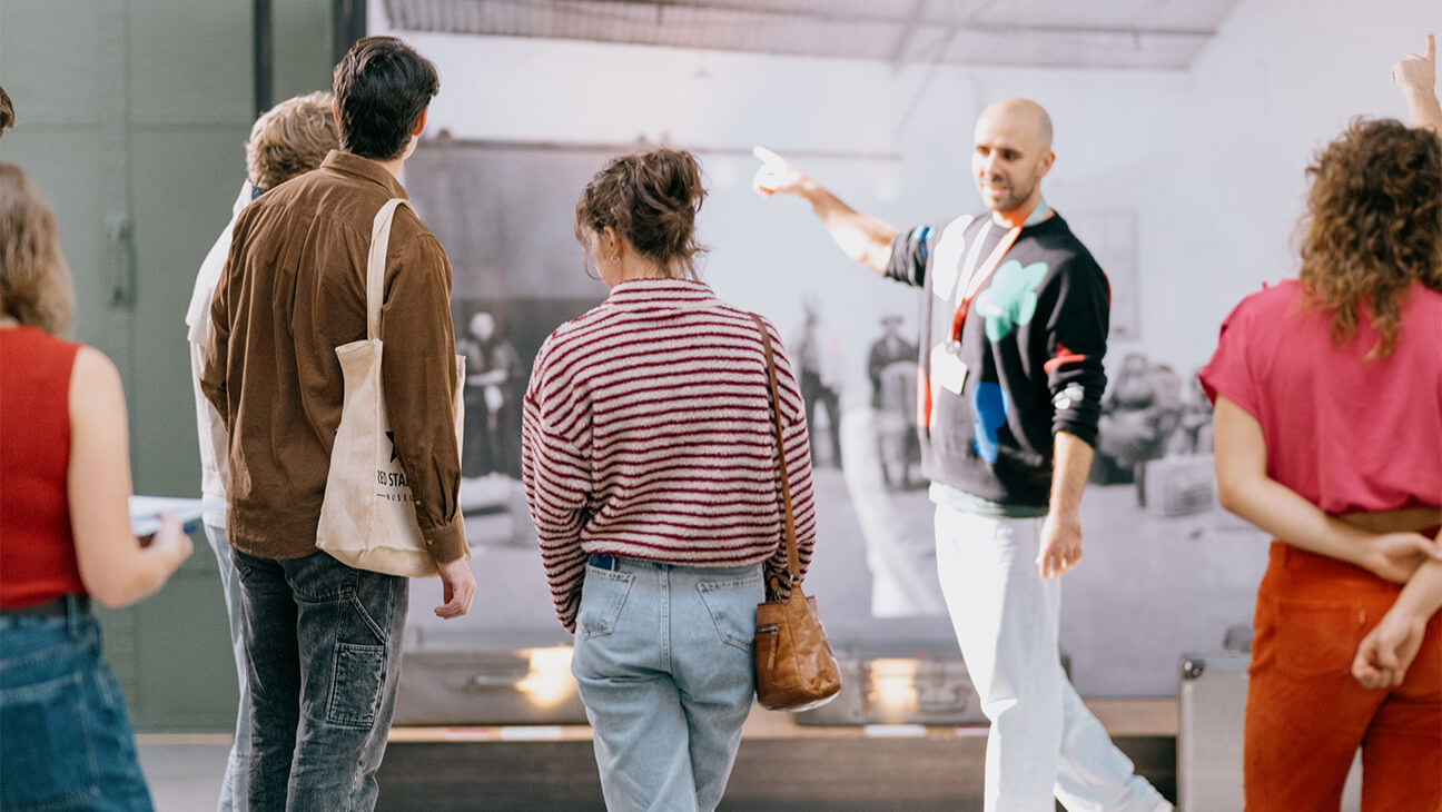 Bezoekers kijken naar een grote foto op doek tijdens de expo 'tussen talen'