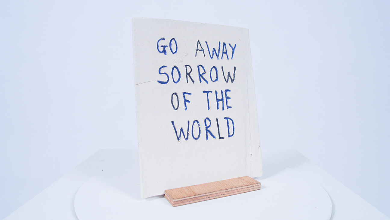 Pancarte met opschrift 'Go Away Sorrow of the World'